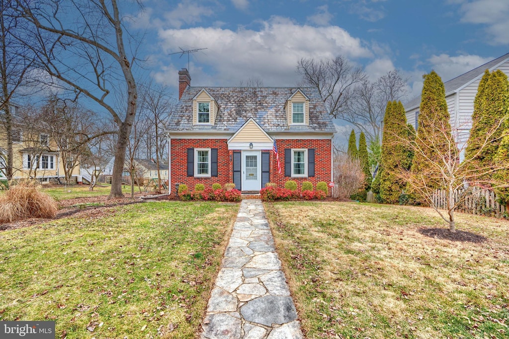 cape cod-style house with a front yard