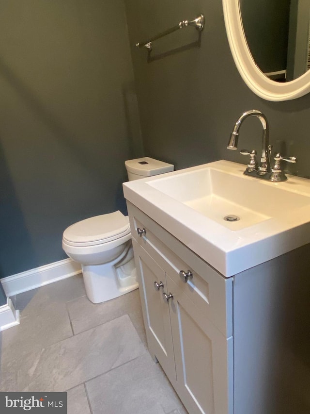 bathroom featuring tile patterned flooring, vanity, and toilet