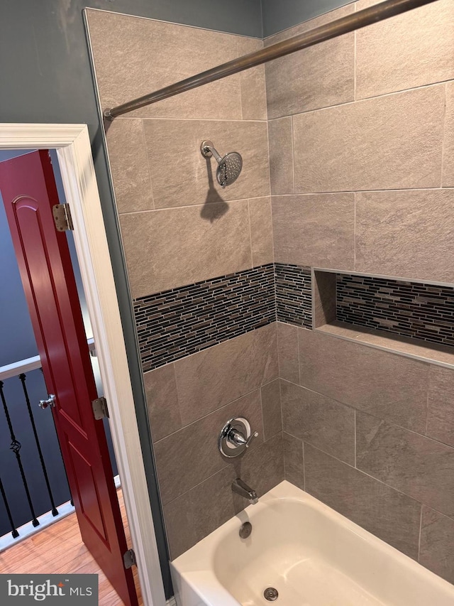 bathroom with tiled shower / bath and hardwood / wood-style floors