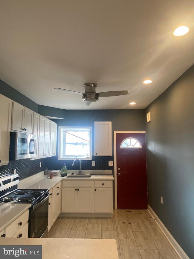 kitchen featuring stainless steel appliances, sink, decorative backsplash, and white cabinets