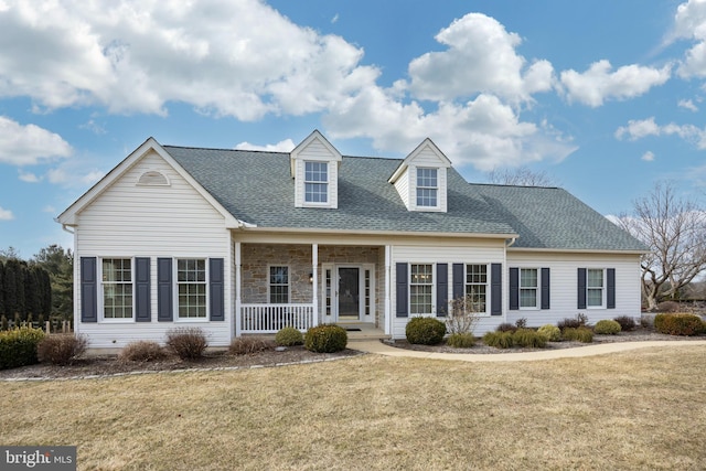 new england style home featuring covered porch and a front yard