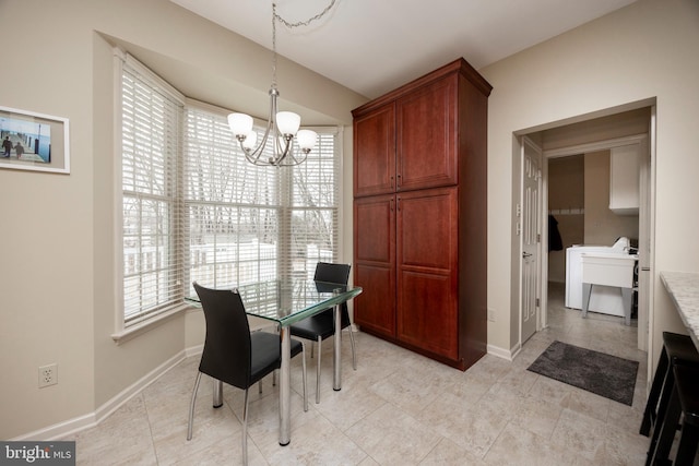 dining space with a healthy amount of sunlight, an inviting chandelier, and sink