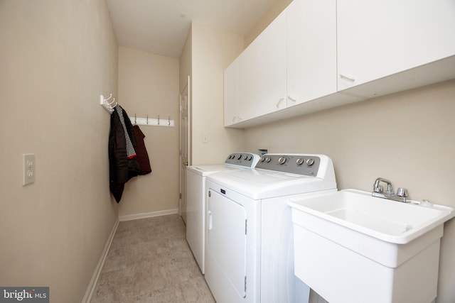 washroom featuring sink, cabinets, and washer and dryer