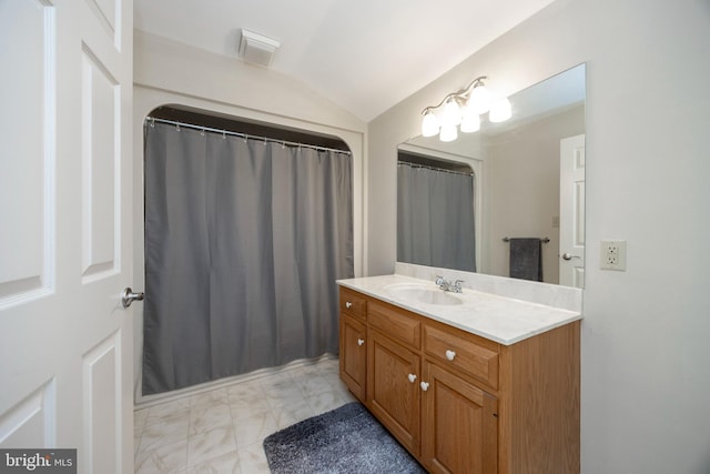 bathroom with vaulted ceiling and vanity