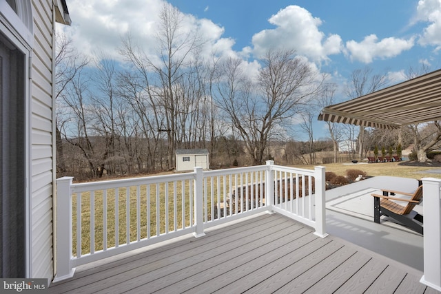 wooden terrace featuring a shed and a lawn