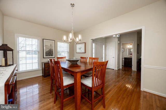 dining area featuring a notable chandelier and dark hardwood / wood-style flooring