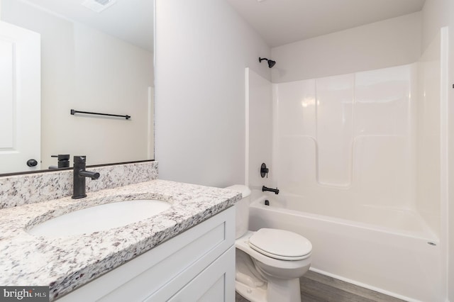 full bathroom featuring hardwood / wood-style floors, vanity, bathing tub / shower combination, and toilet