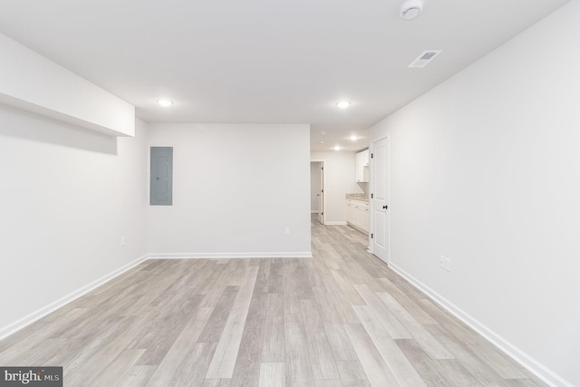 interior space with electric panel and light hardwood / wood-style flooring