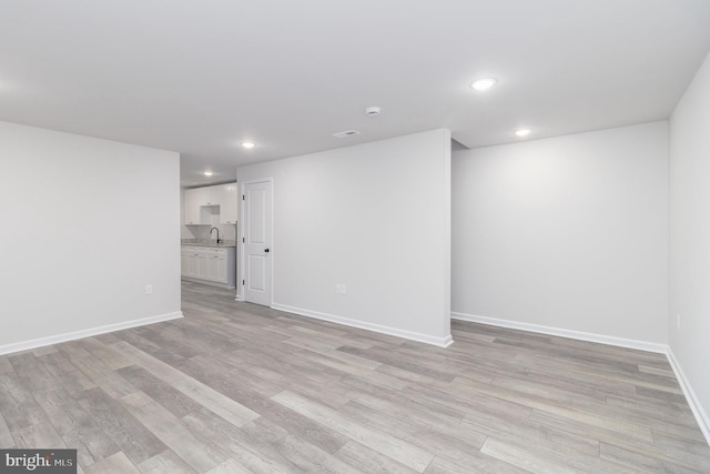 unfurnished room featuring sink and light hardwood / wood-style flooring