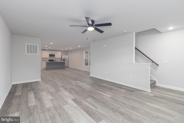 unfurnished living room featuring ceiling fan and light hardwood / wood-style floors