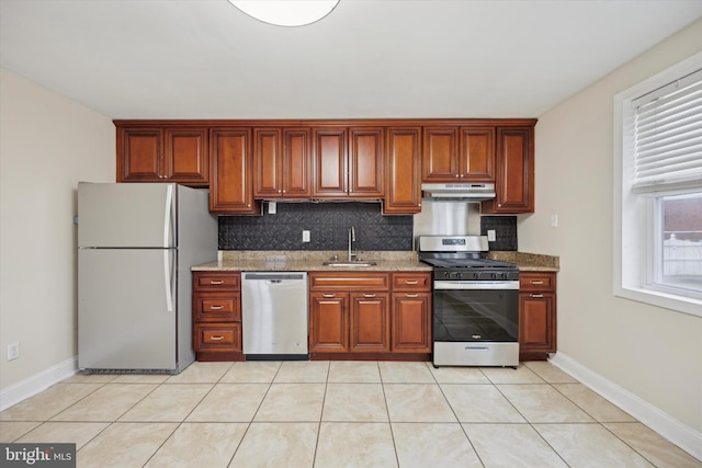 kitchen featuring stainless steel appliances, tasteful backsplash, light stone countertops, and sink