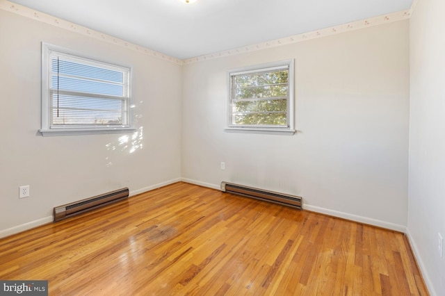 empty room with a baseboard heating unit and light wood-type flooring