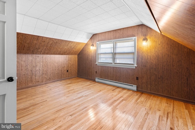 bonus room featuring a baseboard radiator, wooden walls, vaulted ceiling, and light hardwood / wood-style flooring