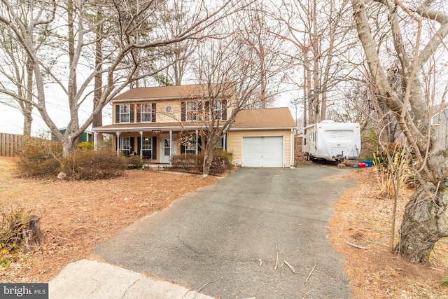 view of front of house featuring aphalt driveway, covered porch, brick siding, and an attached garage