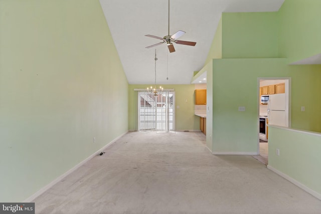 unfurnished living room featuring ceiling fan with notable chandelier, high vaulted ceiling, and light carpet