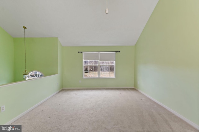 unfurnished room with light colored carpet and lofted ceiling