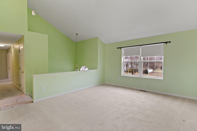 carpeted empty room with high vaulted ceiling