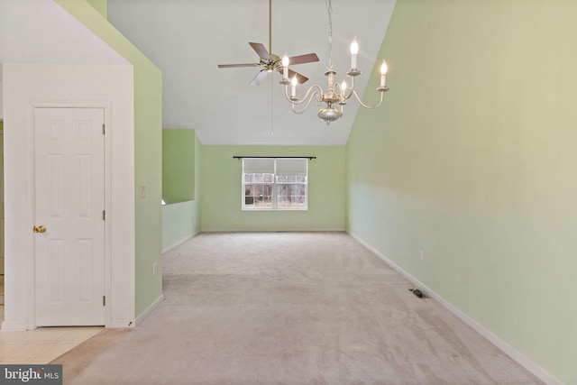 carpeted spare room with ceiling fan with notable chandelier and high vaulted ceiling