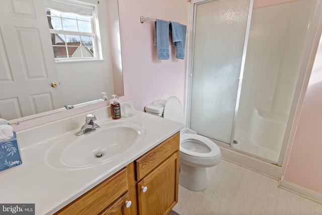 bathroom with vanity, toilet, and a shower with door