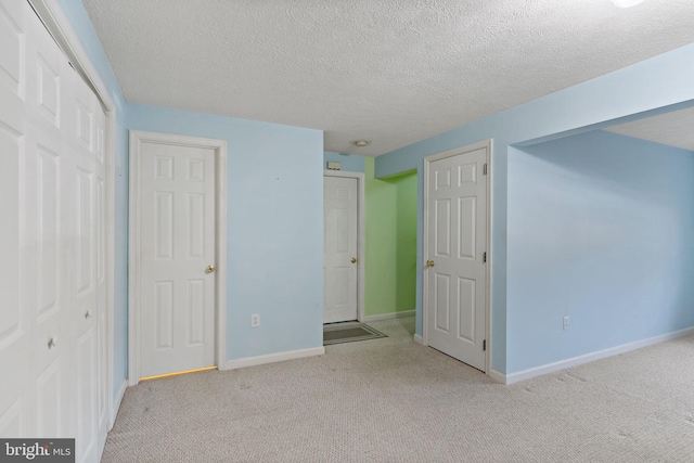 unfurnished bedroom with light colored carpet and a textured ceiling