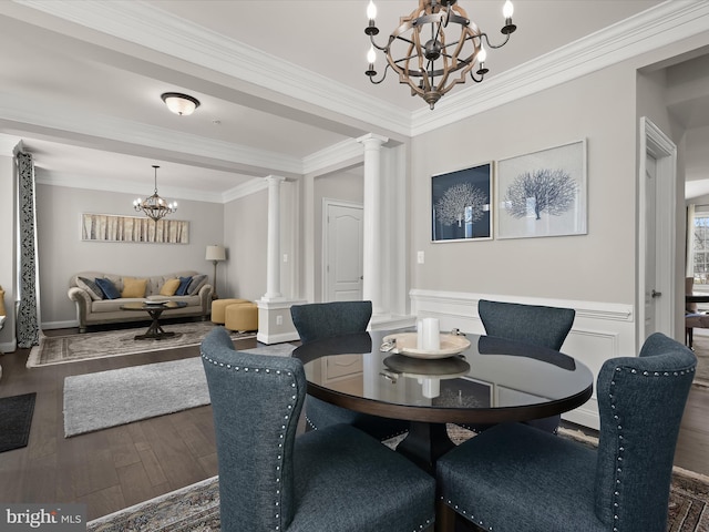 dining space featuring an inviting chandelier, ornamental molding, dark hardwood / wood-style floors, and decorative columns