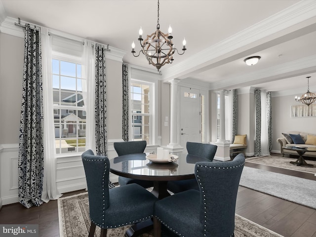 dining space featuring plenty of natural light, dark hardwood / wood-style floors, a chandelier, and ornate columns