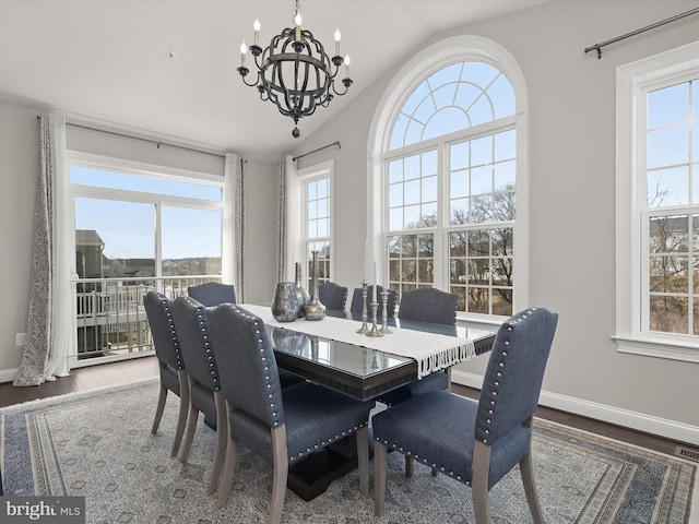 dining room featuring an inviting chandelier, lofted ceiling, and wood-type flooring