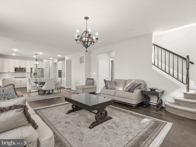 living room featuring an inviting chandelier and dark hardwood / wood-style flooring