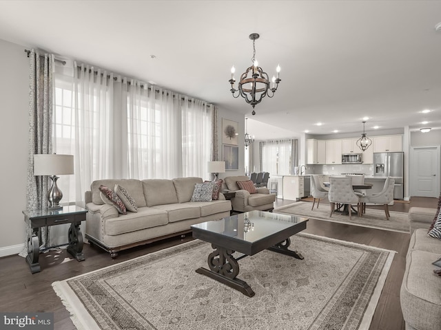 living room featuring dark wood-type flooring and an inviting chandelier