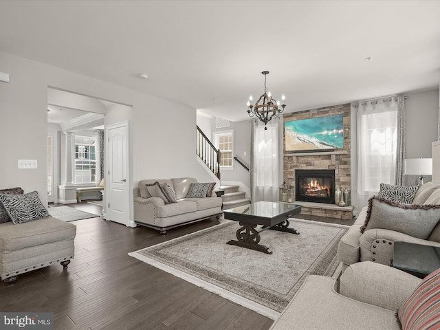 living room featuring a fireplace, dark hardwood / wood-style floors, a chandelier, and a wealth of natural light