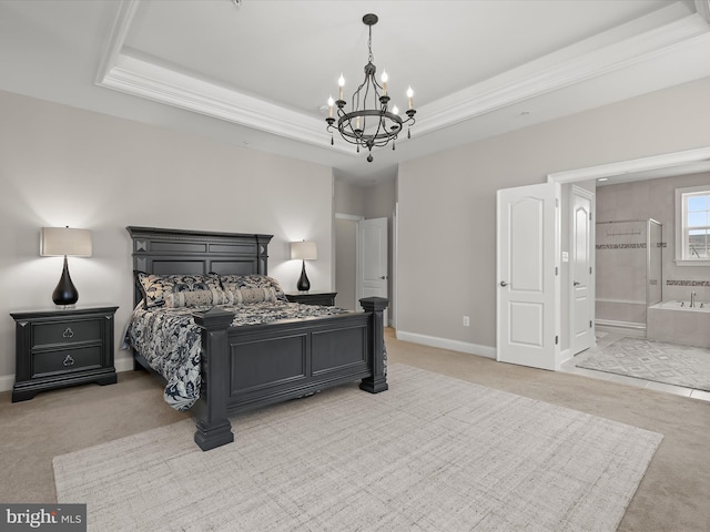 carpeted bedroom featuring an inviting chandelier, a tray ceiling, and ensuite bath