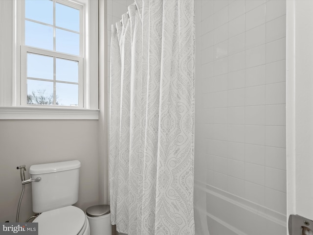 bathroom featuring shower / bath combination with curtain and toilet