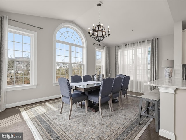 dining room with lofted ceiling, a notable chandelier, and dark wood-type flooring