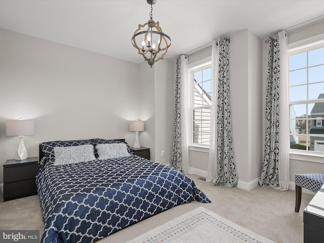 bedroom featuring light carpet and a notable chandelier