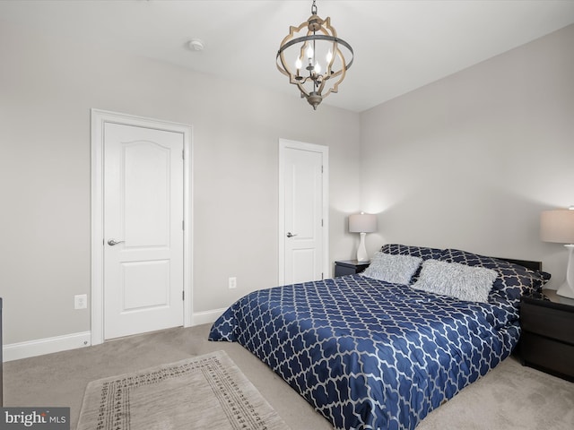 carpeted bedroom featuring an inviting chandelier