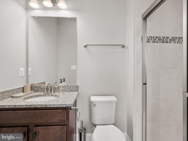 bathroom with an enclosed shower, vanity, and toilet