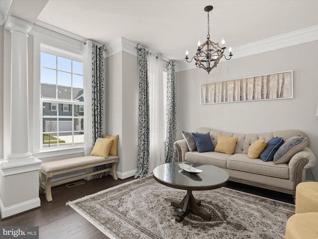 living room with crown molding, decorative columns, dark hardwood / wood-style floors, and a chandelier