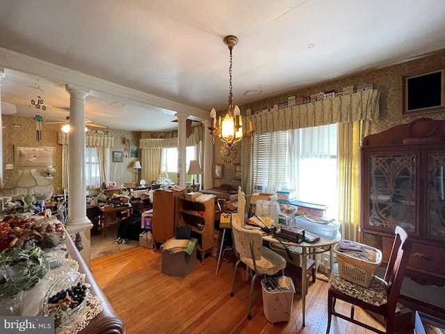 dining area featuring wood-type flooring, ceiling fan, and ornate columns