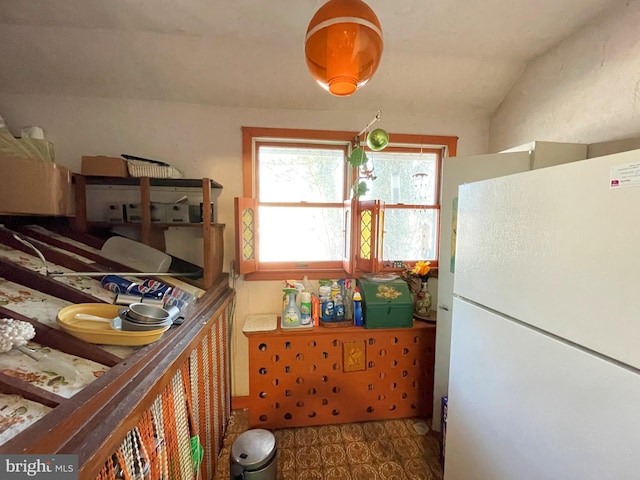 kitchen featuring vaulted ceiling and white refrigerator