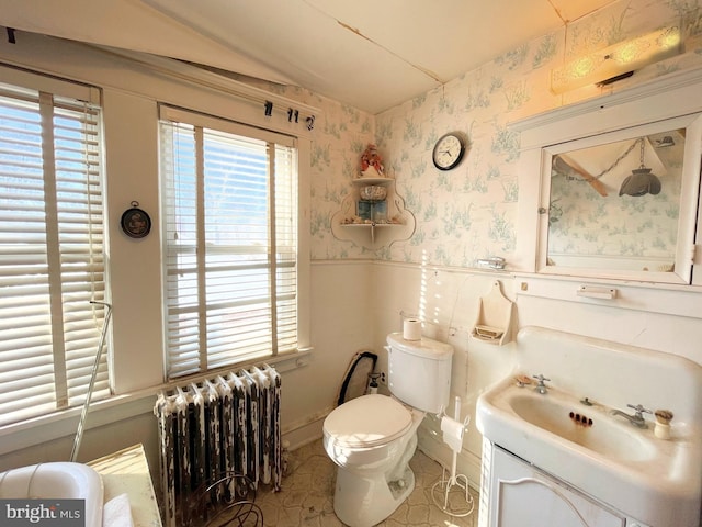 bathroom featuring vanity, plenty of natural light, radiator heating unit, and toilet