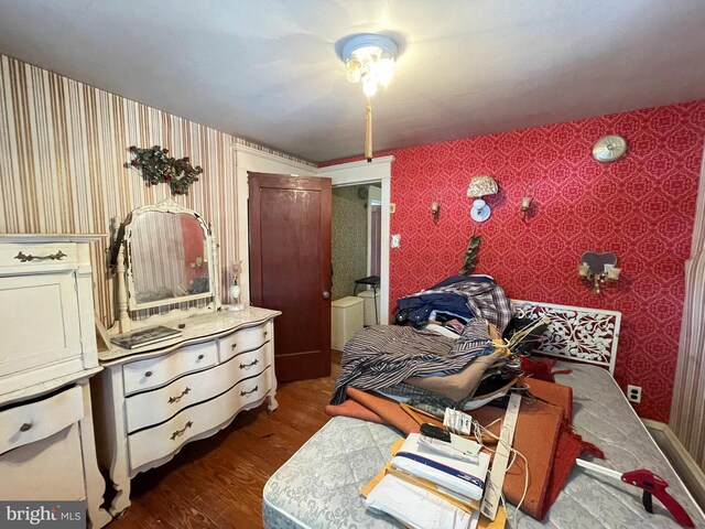 bedroom with dark hardwood / wood-style flooring