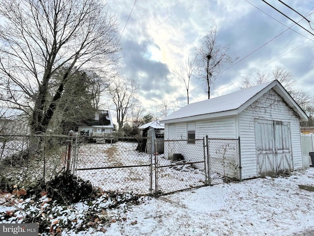 snowy yard with a garage and an outdoor structure