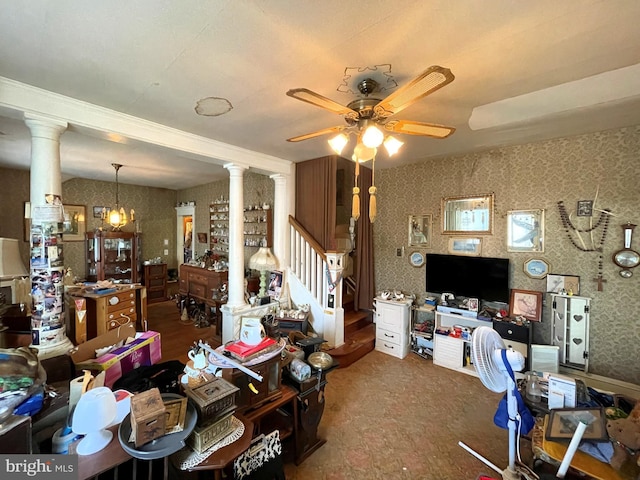 living room featuring ornate columns and ceiling fan with notable chandelier