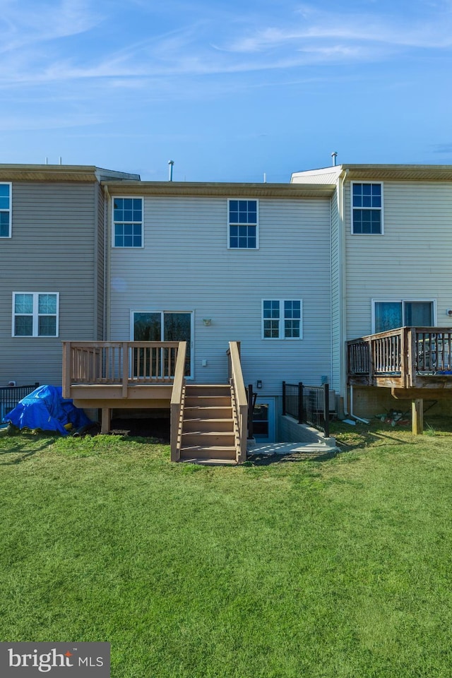 rear view of property with a yard and a deck