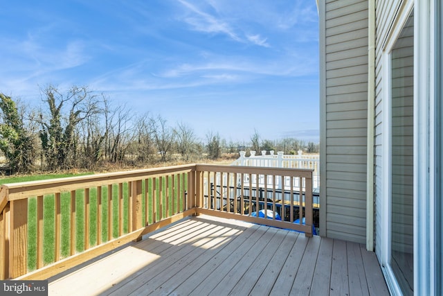 wooden terrace featuring a lawn