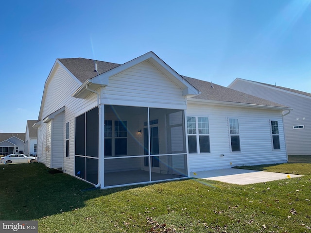 back of house featuring a sunroom, a lawn, and a patio area