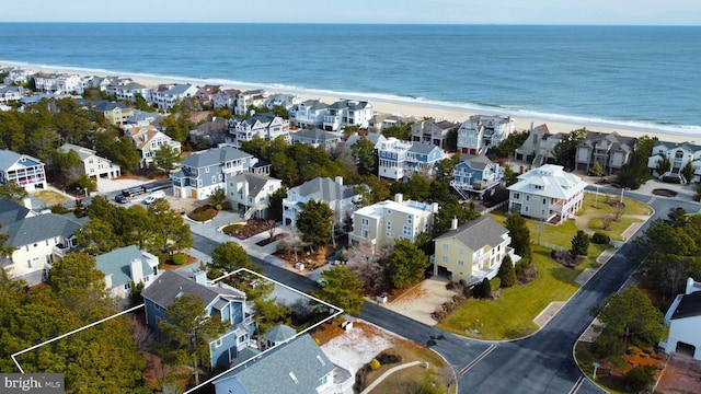 birds eye view of property with a water view, a residential view, and a beach view