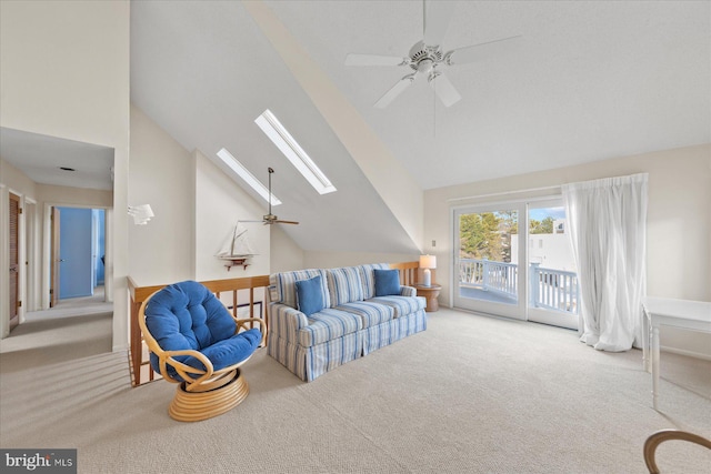 carpeted living area with a ceiling fan, a skylight, and high vaulted ceiling