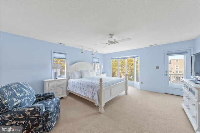 bedroom featuring a ceiling fan, multiple windows, visible vents, and light colored carpet