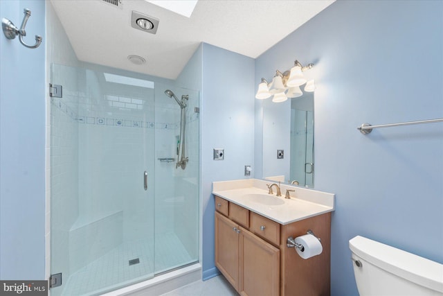 bathroom with toilet, a shower stall, and vanity